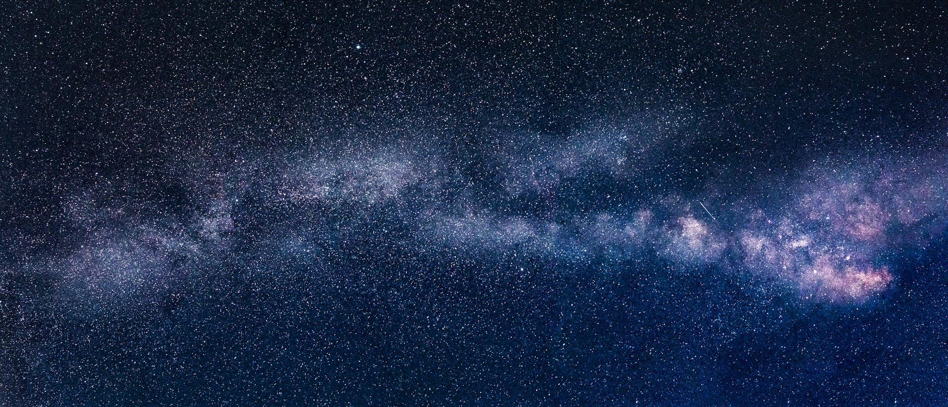 Deep violet and indigo Milky Way stretching across a starlit night sky — evoking the cosmic archive of the Akashic Records